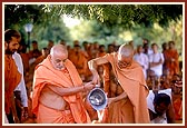Swamishri pours water into the foundation-pit