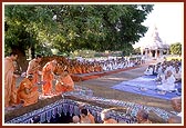 Swamishri performs rituals by the foundation-pit with the Smruti mandir in the background