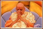 Swamishri is honored with a shawl of fragrant flowers