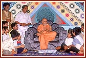 Swamishri happily blesses and converses with children during the Children's Day assembly&nbsp;
