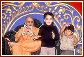 On Children's Day assembly, little children dance to the singing of a bhajan during a kirtan concert. Swamishri participates by playing the kartal