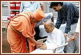 Swamishri blesses the devotee Shri Babubhai Patel, former Chief Minister of Gujarat