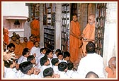 Swamishri blesses the students from Abu by showering rice grains