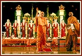 Swamishri performs arti of the murtis, blesses everyone by showering rice grains and addresses the assembly