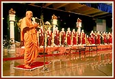 Swamishri performs arti of the murtis, blesses everyone by showering rice grains and addresses the assembly
