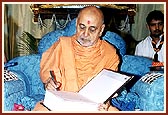 Swamishri signs a catalogue on Panchratna Samhita prepared by sadhus