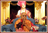 Swamishri humbly bows to the assembly after being honored with a garland of rakhdis