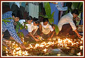 Children offer reverence by setting afloat thousands of diva into the river Sabarmati