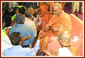 Pujya Doctor Swami, Ishwarcharan Swami, Viveksagar Swami and senior sadhus give the sanctified rakhdis to the devotees