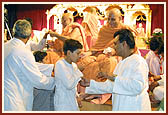 Pujya Doctor Swami, Ishwarcharan Swami, Viveksagar Swami and senior sadhus give the sanctified rakhdis to the devotees