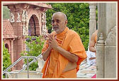 Swamishri bows before the shrines of Hanumanji and Ganapatiji