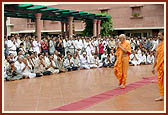 Swamishri bows to the devotees in the mandir precincts while returning to his residence after his puja