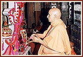 Swamishri performs arti of Thakorji placed in a hindolo made of rakhdis