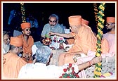 While the Chief Minister holds the kalash containing the Narmada water, Swamishri performs the rituals of worship