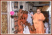 Swamishri offers a ball of roses at the feet of Thakorji