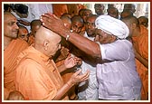 Out of respect Raghu Bharwad places roses on Swamishri's head