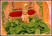 Swamishri offers tulsi leaves to Shri Harikrishna Maharaj during recital of the Janmangal Namavali - the 108 names of Bhagwan Swaminarayan