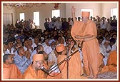 Swamishri sprinkles sanctified water on the devotees