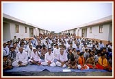 Public assembly seated between rows of BAPS-reconstructed earthquake-resistant homes