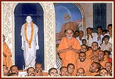 Swamishri with sadhus besides the murti of Yogiji Maharaj at Yogi Smruti Mandir