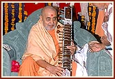 Swamishri sanctifies the musical instruments of a saint who played them while singing kirtans during his morning puja