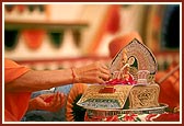Diksha Ceremony: Swamishri offers rose petals to Shri Harikrishna Maharaj while the Janmangal Namavali - 108 names of Shriji Maharaj - is chanted during the mahapuja
