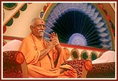 Pujya Doctor Swami claps while a bhajan is being sung by sadhus