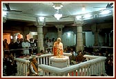 In the mandir rangmandap Swamishri performs abhishek with the water of river Narmada on Shri Nilkanth Varni and offers prayers