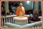 In the mandir rangmandap Swamishri performs abhishek with the water of river Narmada on Shri Nilkanth Varni and offers prayers