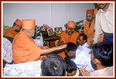 Swamishri sanctifies the home of a veteran tribal volunteer (in Sarvani) who has been offering his services since the initiation of satsang activities in the tribal area