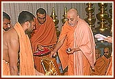 Swamishri ritually performs pujan of the flagstaffs