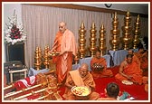 Swamishri and senior sadhus perform arti of kalashas and the murtis to be installed at the Hari mandir in Gujarat Vihar