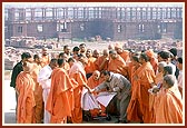 Swamishri observes the plans and discusses about the complex. In the background are sections of the parikrama