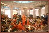 Swamishri offers a coconut into the yagna during the vastu pravesh rituals of the mandir