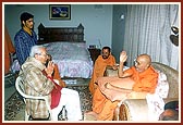 Shri Chandrakantbhai Trivedi is seen bowing and listening to Swamishri's blessings.