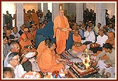 Beneath the mandir dome, Swamishri and devotees perform arti during the vastu puja rituals