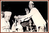 Garlanded by a local devotee while sitting in a bullock cart in Sakore