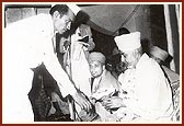 Shri Chhabildas Rajdhar offers a bouquet and honors Swamishri during a satsang assembly in Galvada, 1976