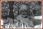 Swamishri is garlanded by a devotee outside his home in Kusumbe, 1976