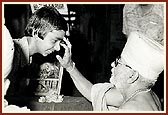 During a home-visit Swamishri blesses a child by doing chandlo, Dhuliya