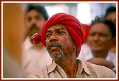 A tribal devotee listening intently