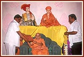 Officials from the municipality present Swamishri with a plaque of honor