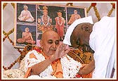 Swamishri is welcomed with a garland by a devotee