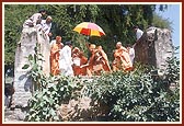 Shastriji Maharaj used to come to bathe at this well outside the village. Swamishri is engaged in darshan, prayers and sprinkling of the holy well water on his head