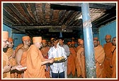Swamishri showers flower petals to sanctify the house