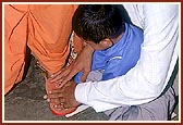 A father teaches his son to touch the feet of Swamishri