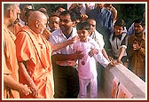 Swamishri blesses and inspires a satsangi balak for his paintings
