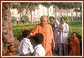 Swamishri respectfully places a flower on the balak's head