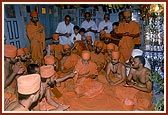 Swamishri and sadhus sing dhun in the mandir