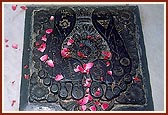 Charnarvind (footprints) at the memorial mandir, Laxmivadi (When Shriji Maharaj was having His murti sculpted for installing it in the Gadhada mandir it broke. Then Sadguru Nishkulanand Swami carved this pair of charnarvinds from the chest area of the murti.)